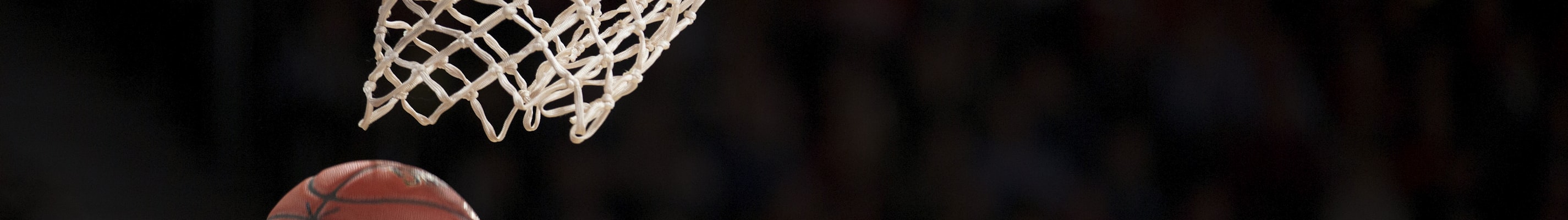 篮球运动员高高跃起完成扣篮的精彩动作